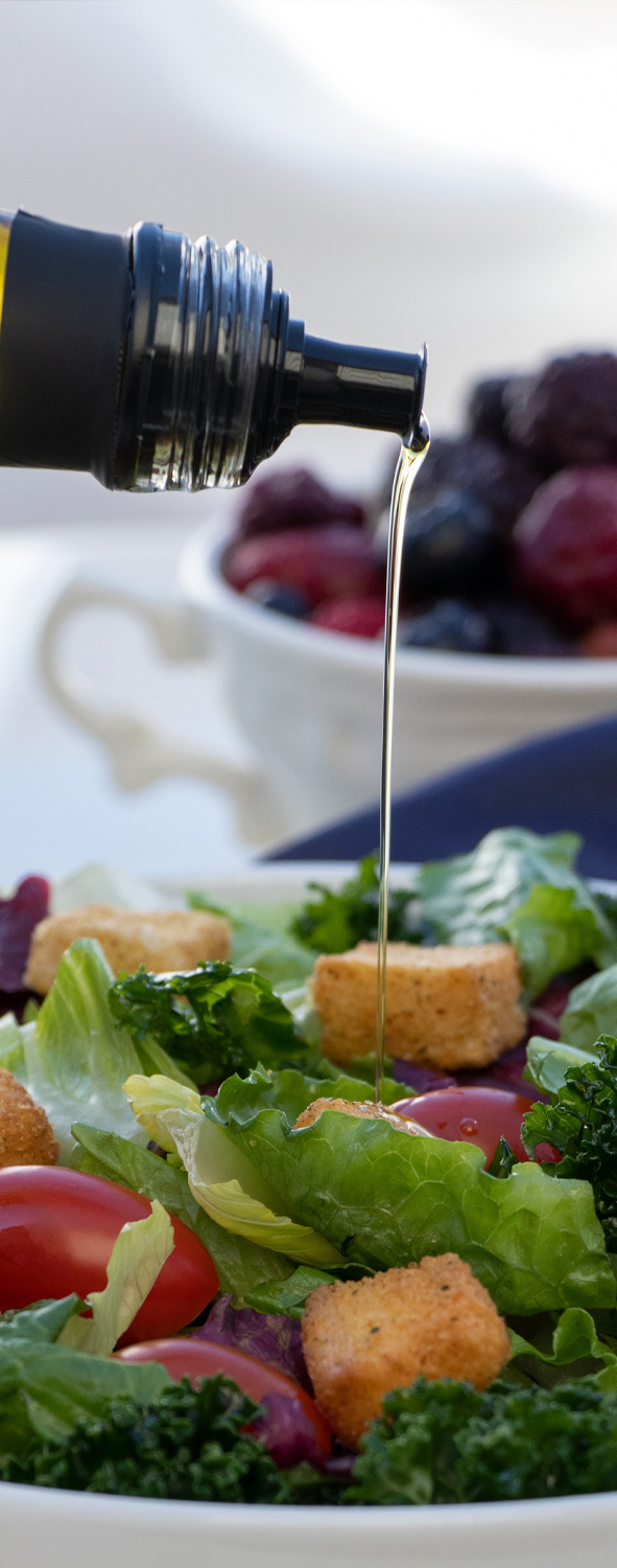 Esmea organic olive oil pouring onto a salad